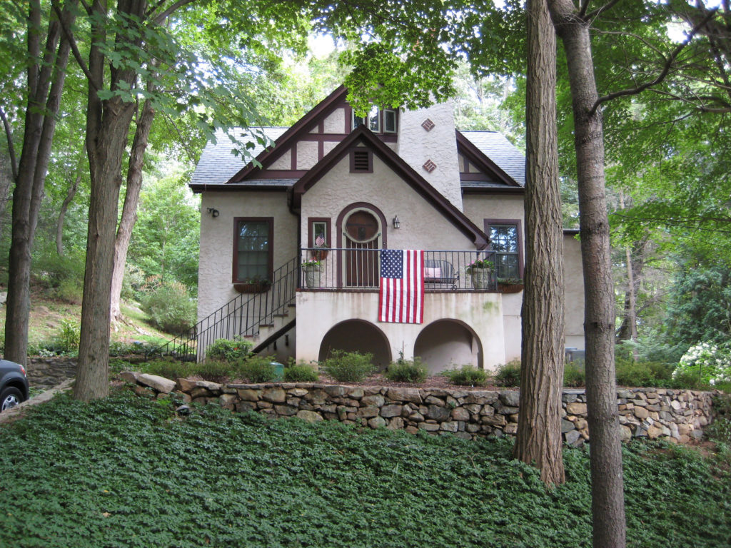 A photo of the little cottage in the woods in the present day, now with a second floor added to it.