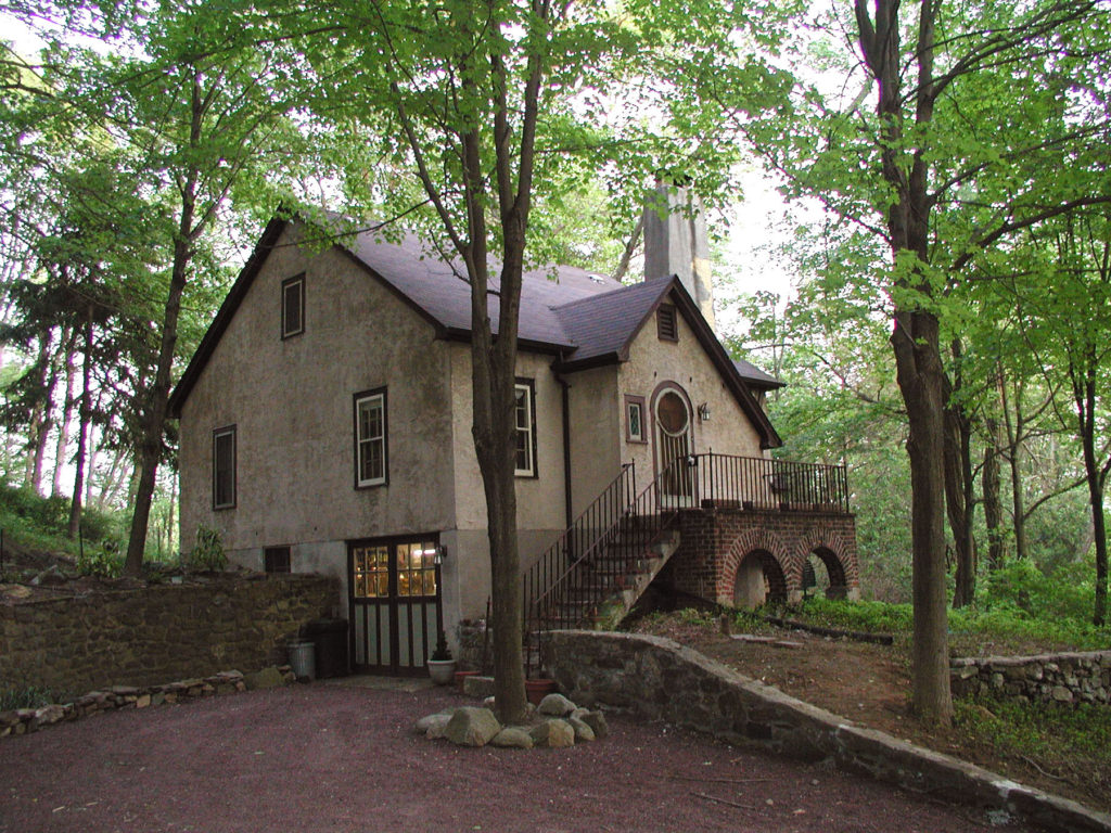 A photo of the little cottage in the woods in the present day, now with a second floor added to it.