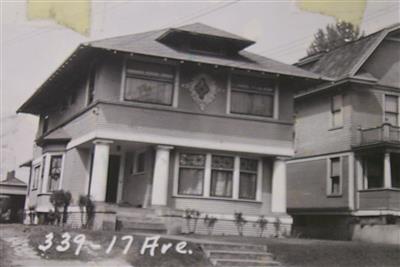 A black and white photo of a historic house in the past.