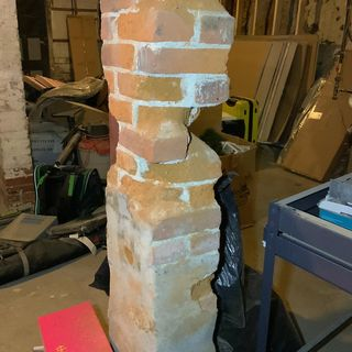 A dangerous basement support column with bricks missing.