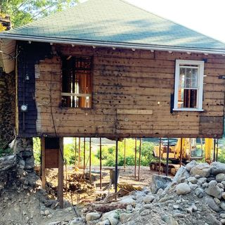 A house with no foundation, apparently held up by narrow beams with nothing in between.