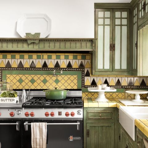 A yellow and green kitchen with a bold geometric tile backsplash and tile countertops.