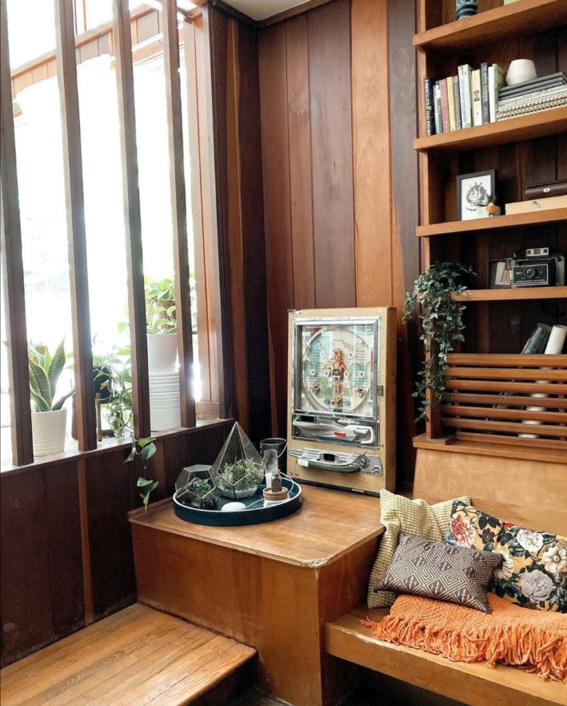 A corner of the living room, featuring lots of wood furniture and wood panel.