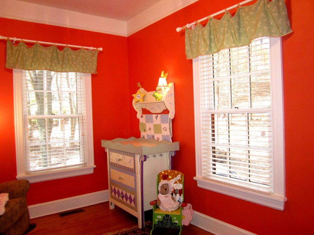 A photo inside a nursery which is painted bright red.