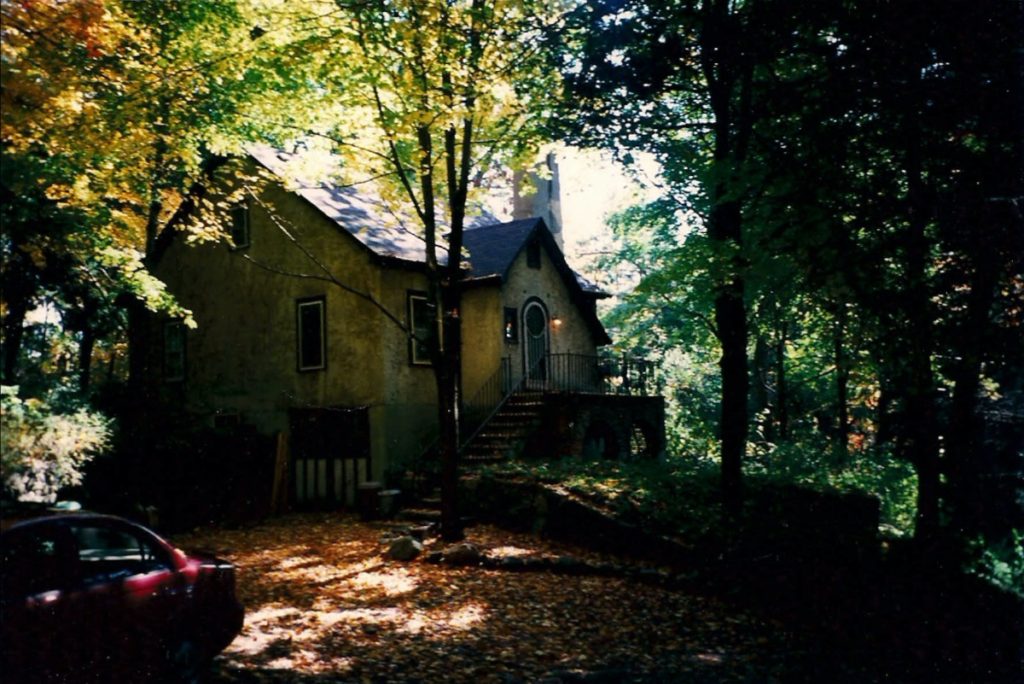 A photo of the cottage in the woods on a sunny day.