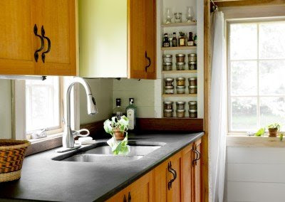 The kitchen of the tiny house, with a double sink and a spice rack.