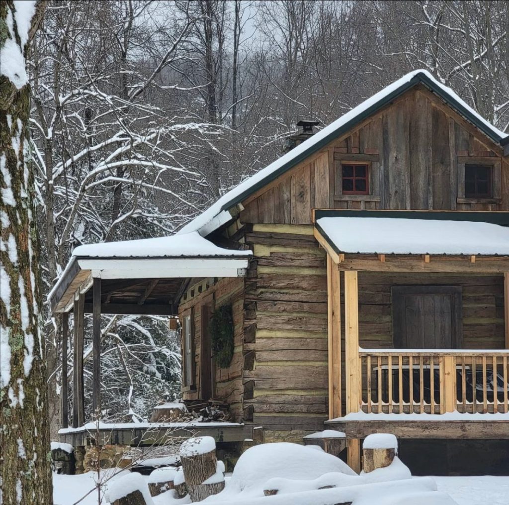 The log cabin after renovation, covered in a thin layer of snow