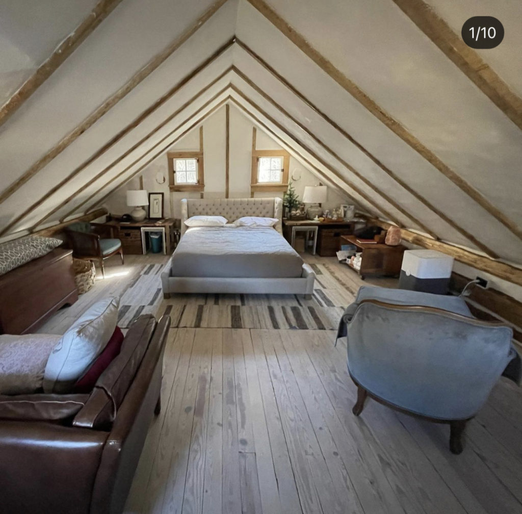 The log cabin main bedroom, with exposed beams in the gable ceiling. 