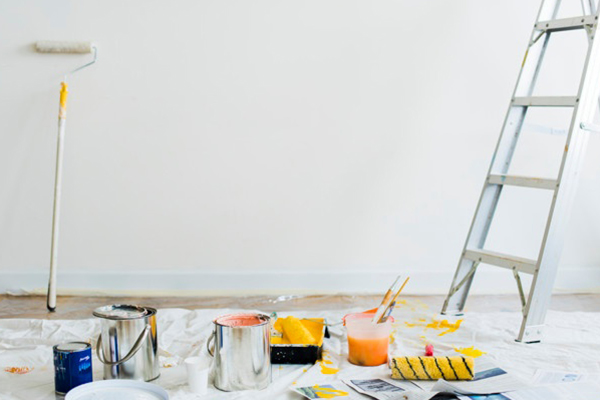 Painting supplies and a ladder on a drop cloth