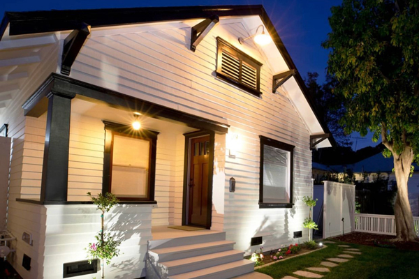 A timeless-looking white house with black trim at night.