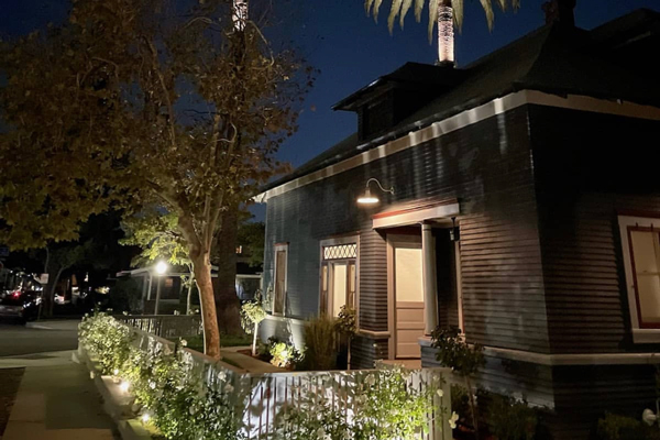 One of Hugh's historic home restoration projects at night: a small, cute one story house.