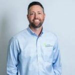 A headshot of Brent Pearson, home foundation repair expert. He is a light-skinned man with dark hair and a short beard. He's wearing a blue oxford button-down and smiling at the camera.