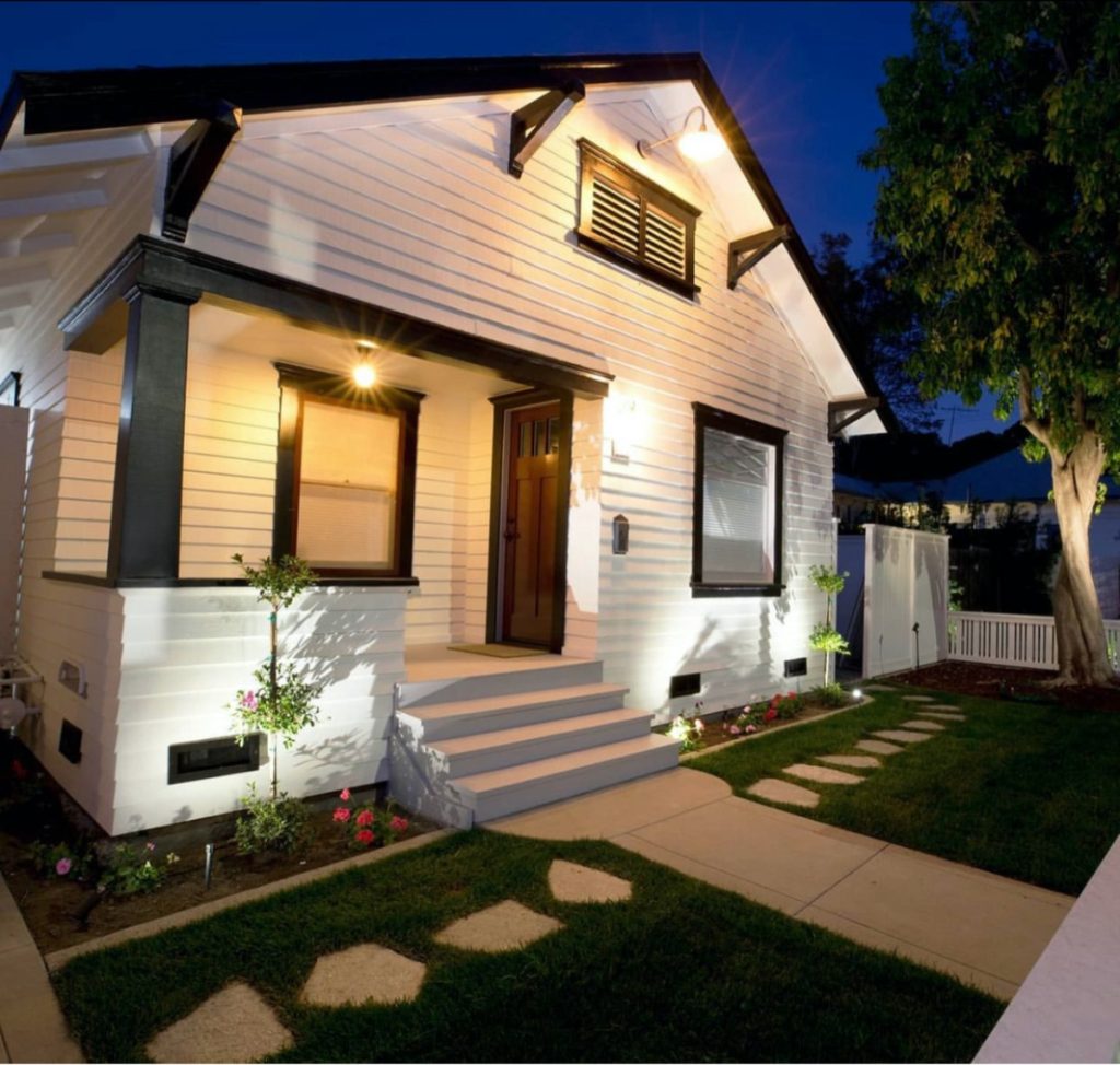 A timeless-looking white house with black trim at night.